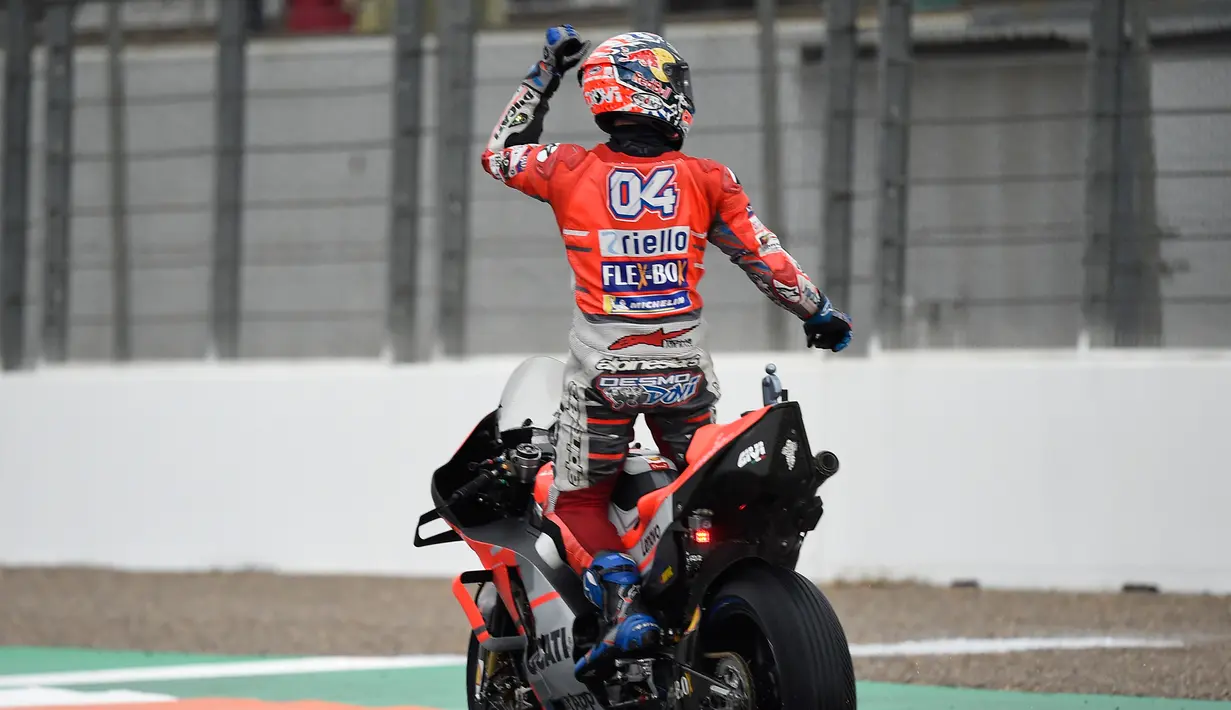 Pebalap Ducati, Andrea Dovizioso berselebrasi merayakan kemenangan MotoGP Grand Prix Valencia di arena balapan Ricardo Tormo, Cheste, Minggu (18/11). Andrea membukukan waktu 24 menit 3,408 detik terhitung pada sesi kedua. (Jose Jordan/AFP)