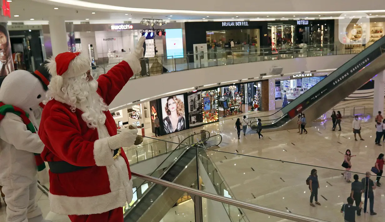 Petugas yang mengenakan kostum Sinterklas menyapa pengunjung di Senayan City Mall, Jakarta, Jumat (25/12/2020). Kegiatan tersebut bertujuan untuk melengkapi kebahagiaan Natal tahun 2020. (Liputan6.com/Herman Zakharia)