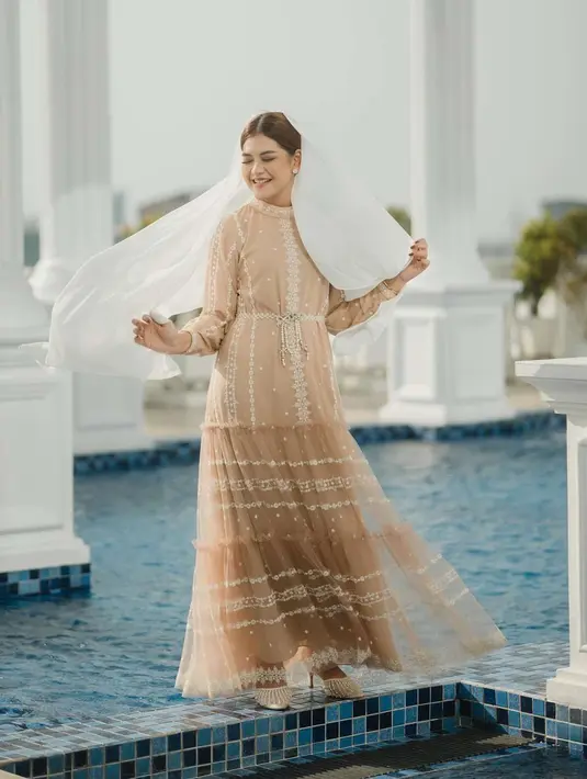 Cantiknya Kahiyang Ayu memadukan busana lacenya yang bernuansa cokelat muda dengan selendang putih yang menutupi rambutnya. [Foto: Instagram/ayanggkahiyang]