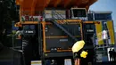 Salah satu SPG berdiri di depan sebuah truk pertambangan yang dipamerkan dalam ajang "Expomin 2014", sebuah pameran dua tahunan pertambangan di Santiago, Chili, (21/4/2014). (REUTERS/Ivan Alvarado)
