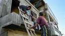 Saat ini, penanganan banjir Pidie Jaya kini memasuki fase respons cepat. Warga diminta tetap tenang di tempat pengungsian sambil menunggu bantuan yang segera dikirim melalui jalur udara dan darat. Tampak dalam foto, seorang pria berbagi kopi dengan seorang warga yang terlantar setelah banjir bandang di Meureudu, Kabupaten Pidie Jaya, Provinsi Aceh, pada 30 November 2025. (CHAIDEER MAHYUDDIN/AFP)