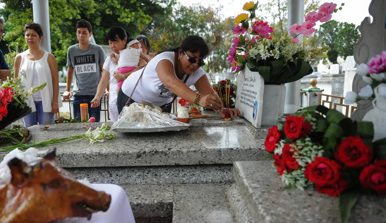 Masyarakat keturunan Tionghoa membakar dupa saat mengunjungi makam leluhur pada festival tahunan Qingming (Cheng Beng) di Hanava, Minggu (3/4). Festival ini merupakan tradisi ziarah dan membersihkan makam sesuai ajaran Khonghucu. (AFP PHOTO/Yamil LAGE)