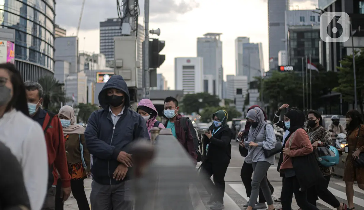 Pejalan kaki melintasi "pelican crossing" untuk menyeberang jalan di kawasan Thamrin, Jakarta, Kamis (5/1/2023). Pencabutan Pemberlakuan Pembatasan Kegiatan Masyarakat (PPKM) dinilai untuk menggenjot ekonomi Indonesia 2023 yang diproyeksi suram akibat resesi global. (Liputan6.com/Faizal Fanani)