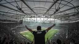 Aksi suporter Besiktas saat mendukung timnya bertanding melawan Bursaspor dalam laga Liga Super Turki di Stadion Vodafone Arena, Istanbul, Turki, (11/4/2016). (AFP/Ozan Kose)