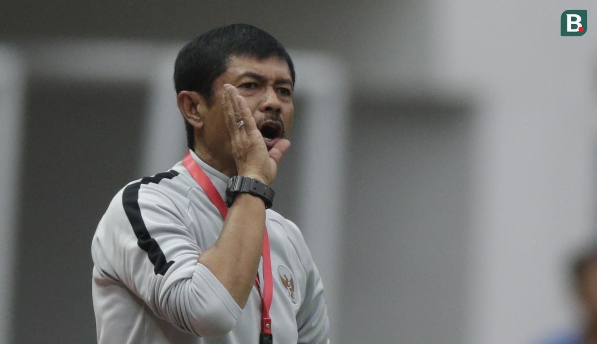 Pelatih Indonesia, Indra Syafri, memberikan arahan kepada anak asuhnya saat melawan Yordania pada laga persahabatan di Stadion Wibawa Mukti, Jawa Barat,  Sabtu (13/10/2018). Indonesia menang 3-2 atas Yordania. (Bola.com/M Iqbal Ichsan)