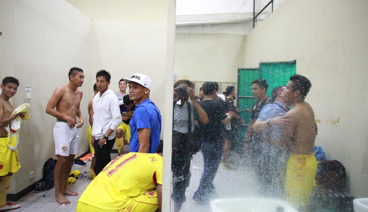 Ferdinan Sinaga (biru) dan Tim Sriwijaya FC merayakan kemenangan diloker room usai mengalahkan Arema Cronus di Stadion Manahan, Solo, Minggu (11/10/2015). (Bola.com/NIcklas Hanoatubun)