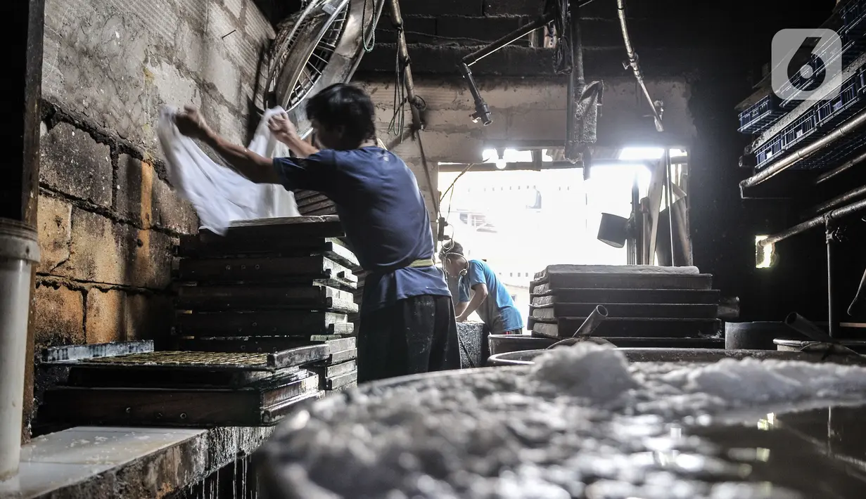Pekerja menyelesaikan pembuatan tahu di industri rumahan kawasan Mampang, Jakarta, Minggu (30/8/2020). Menurunnya produksi disebabkan pelanggan, terutama pengusaha warung makan yang terpaksa tutup akibat diterapkannya PSBB sehingga berpengaruh pada omzet penjualan. (merdeka.com/Iqbal S. Nugroho)