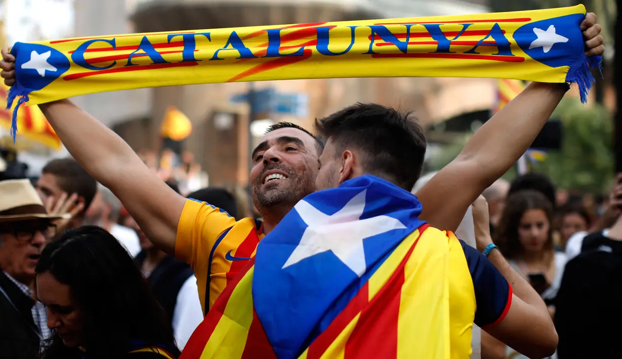 Seorang pria bersorak ketika Parlemen Catalonia mendeklarasikan kemerdekaan dari Spanyol di luar gedung parlemen di Barcelona, Jumat (27/10). Sejumlah pendukung kemerdekaan, turun ke jalan dan menyanyikan lagu tradisional Catalan. (AP/Emilio Morenatti)