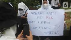 Massa dari Forum Komunikasi Nakes dan Non-Nakes Indonesia (FKHN Indonesia) membawa poster tuntutan saat menggelar aksi di kawasan Patung Kuda, Jakarta Pusat, Kamis (22/9/2022). Mereka menuntut Presiden Joko Widodo segera menerbitkan Peraturan Presiden (PP) khusus yang mengatur honorer nakes dan nonnakes bisa diangkat menjadi Aparatur Sipil Negara (ASN). (Liputan6.com/Herman Zakharia)