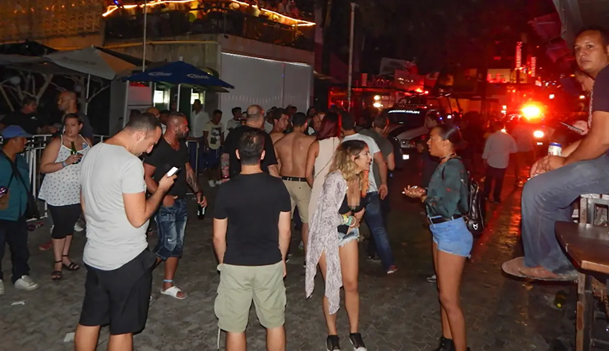 Suasana di sekitar lokasi penembakan yang terjadi di kelab malam Blue Parrot dievakuasi oleh tim medis, Meksiko (16/1). Di lokasi kejadian, polisi menemukan 20 selongsong peluru. (AFP/Victor Vargas)