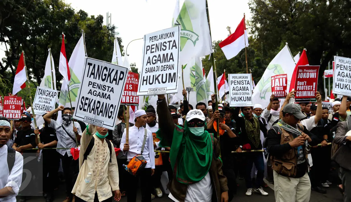 Massa aksi damai 4 November meneriakkan yel-yel sambil membawa atribut saat melewati Balai Kota Jakarta menuju ke Istana Merdeka, Jumat (4/11). Aksi ini menuntut penuntasan proses hukum terhadap Basuki Tjahaja Purnama (Ahok). (Liputan6.com/Faizal Fanani)