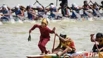 Seorang anak laki-laki menari di bagian depan perahu tradisional selama festival balap perahu Pacu Jalur di Sungai Kuantan, Kabupaten Kuantan Singingi, Provinsi Riau, pada 21 Agustus 2025. (Wahyudi/AFP)