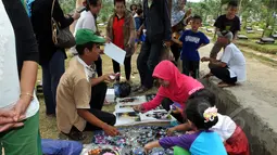 Seorang calon pembeli melihat barang dagangan yang menjual berbagai macam pernak-pernik Olga Syahputra di TPU Malaka, Jakarta, Selasa (31/3/2015). (Liputan6.com/Panji Diksana) 
