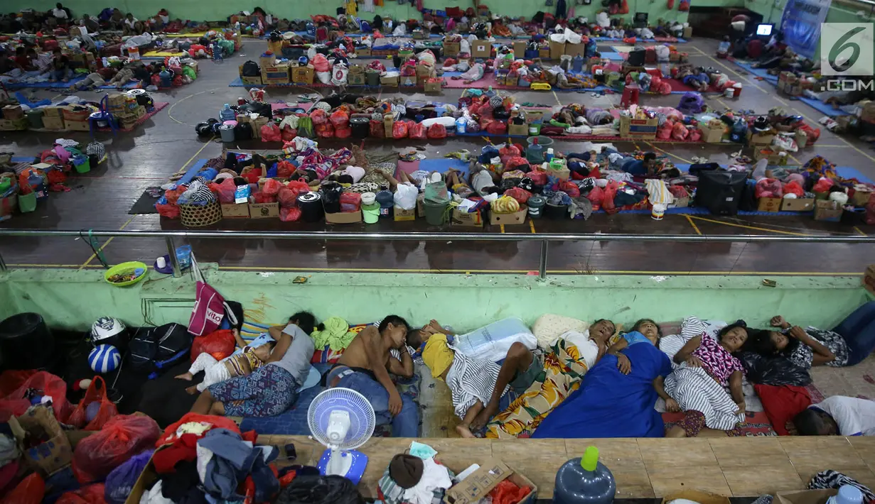 Sejumlah pengungsi Gunung Agung berisitirahat di lokasi pengungsian GOR Swecapura, Klungkung, Bali, Minggu (3/12). Pengungsi Gunung Agung yang berada di Kabupaten Klungkung terus bertambah dengan total 9.304 jiwa. (Liputan6.com/Immanuel Antonius)