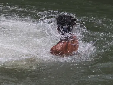 Seorang pemuda menyejukkan diri di perairan yang mengalir di Taman Tonkawa dekat Crawford, Texas, Jumat, 16 Juni 2023. Suhu diperkirakan akan mencapai angka 100 derajat Fahrenheit selama beberapa hari ke depan. (Rod Aydelotte/Waco Tribune-Herald via AP)
