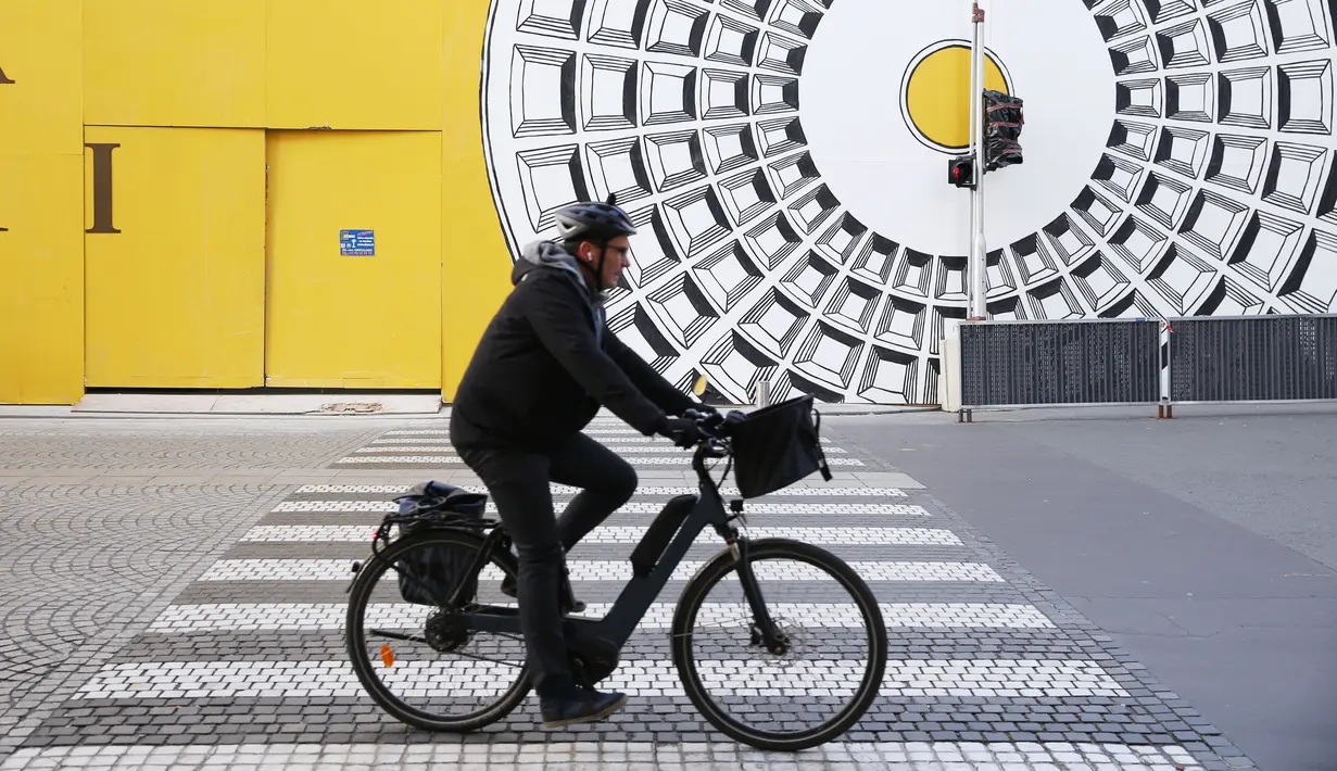 Seorang pria mengendarai sepeda di sebuah jalan di Paris, Prancis, 25 November 2020. Warga Prancis akan menikmati lebih banyak kebebasan dalam melakukan berbagai kegiatan di luar ruangan mulai 28 November 2020.(Xinhua/Gao Jing)