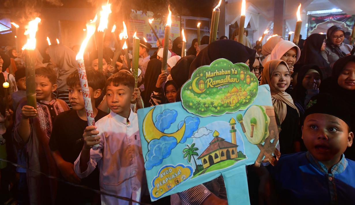 Ini merupakan tradisi menyambut datangnya bulan suci Ramadan 1447 Hijriah. Tampak dalam foto, anak-anak saat mengikuti pawai obor di kawasan Cinere,  Depok, Senin (16/2/2026). (merdeka.com/Arie Basuki)