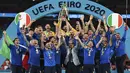 Para pemain Italia mengangkat trofi juara Euro 2020 usai mengalahkan Inggris pada pertandingan final di Stadion Wembley, London, Inggris, Minggu (11/7/2021). Italia menang 3-2 lewat adu penalti usai bermain imbang 1-1 di waktu normal. (Michael Regan/Pool via AP)