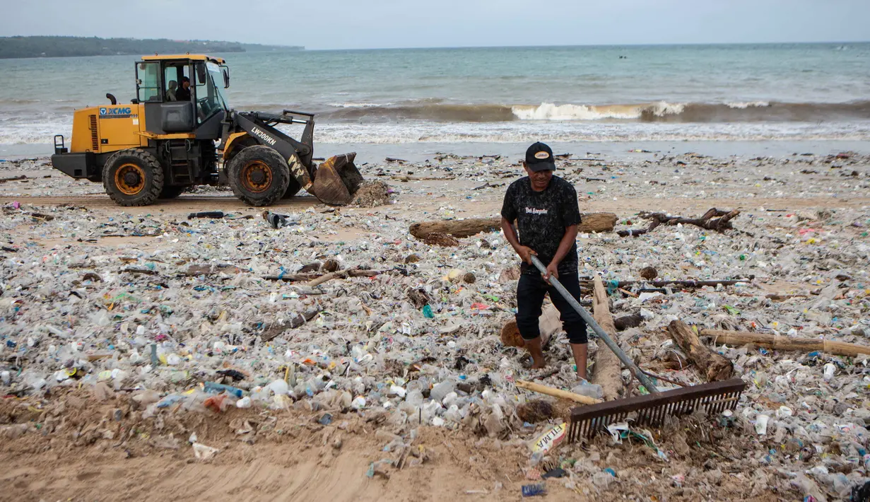 Sebagai komitmen menjaga citra pariwisata Bali, ribuan relawan, termasuk TNI-Polri bersama-sama melakukan aksi bersih pantai (korve) serentak di Pantai Jimbaran sejak 5 Maret 2026. Tampak dalam foto, para pekerja dan warga membersihkan ceceran dan tumpukan sampah plastik yang terdampar di Pantai Jimbaran, Bali, pada Selasa 10 Maret 2026. (Lana Priatna/AFP)
