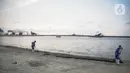Petugas membersihkan pantai ancol yang sepi usai ditutup antisipasi COVID-19, Jakarta, Sabtu (14/3/2020). Selama masa penutupan, Taman Impian Jaya Ancol akan melakukan kegiatan overhaul seluruh wahana dan membersihkan fasilitas rekreasi dengan disinfektan. (Liputan6.com/Faizal Fanani)