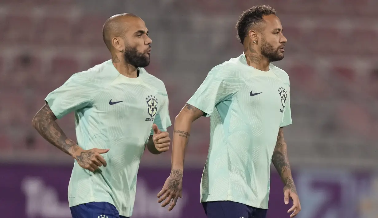 Penyerang Brasil Neymar dan rekan setimnya Dani Alves menghadiri sesi latihan jelang menghadapi Timnas Serbia di stadion Grand Hamad, di Doha, Qatar, Rabu (23/11/2022). Tim Samba konon akan tampil habis-habisan di lini serang demi memetik kemenangan pertama di ajang Piala Dunia 2022 . (AP Photo/Andre Penner)