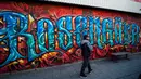 Seorang pwarga berjalan melewati tembok graffiti  dekat lapangan sepak bola Zlatan di kawasan Rosengard, Malmoe, (2/5/2016). (AFP/Jonathan Nackstrand)