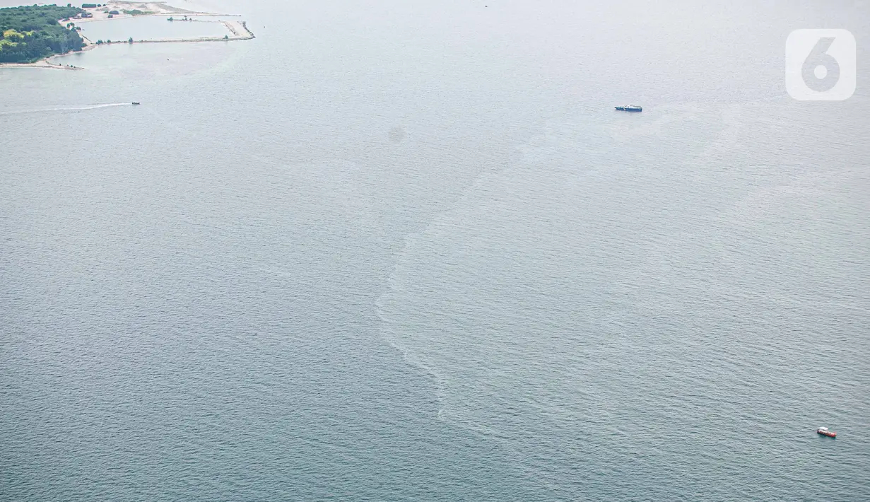 Foto dari udara memperlihatkan tim gabungan melakukan proses pencarian pesawat Sriwijaya Air SJ 182 yang hilang kontak di sekitar perairan Kepulauan Seribu, Jakarta, Minggu (10/1/2021). Dari pantauan udara terlihat tumpahan minyak yang diduga milik Sriwijaya Air SJ 182. (Liputan6.com/Faizal Fanani)