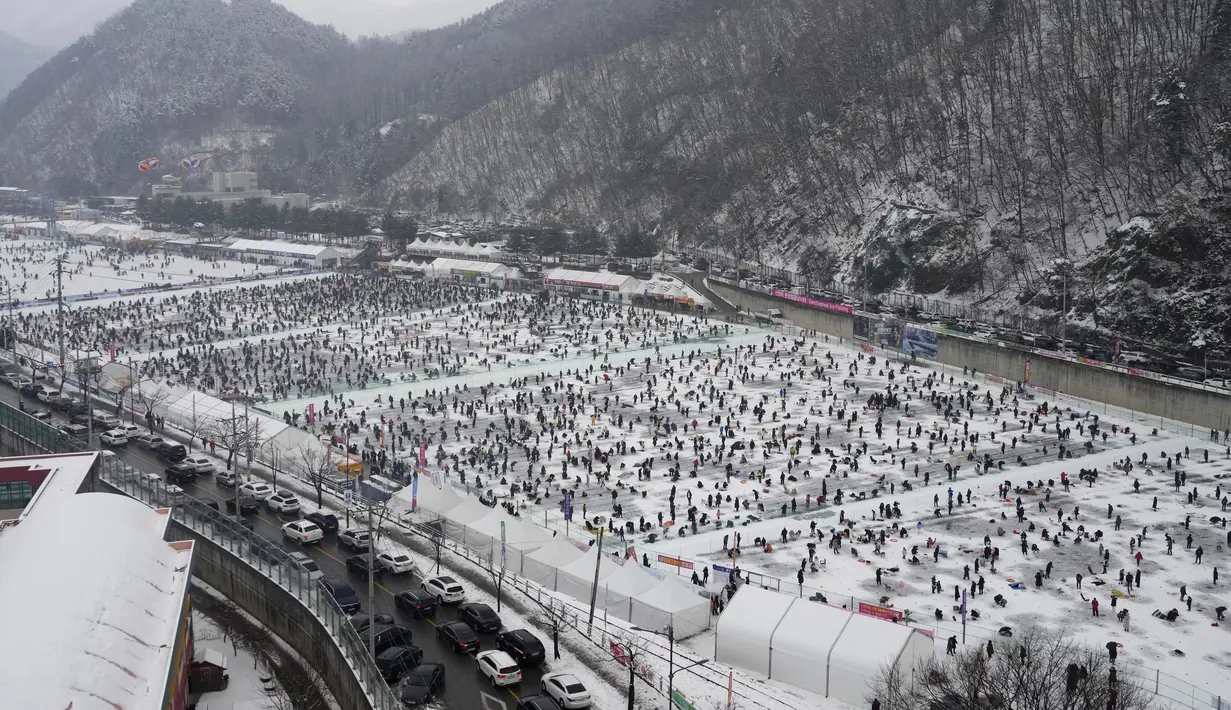 Para peserta memancing ikan trout melalui lubang yang mereka buat di atas sungai beku di Hwacheon, Korea Selatan, Sabtu (7/1/2023). Kontes ini merupakan bagian dari festival es tahunan yang menarik lebih dari satu juta pengunjung setiap tahun. (AP Photo/Ahn Young-joon)