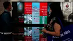 Pekerja tengah melintas di bawah layar Indeks harga saham gabungan (IHSG) di BEI, Jakarta, Selasa (16/5/2023). (Liputan6.com/Angga Yuniar)
