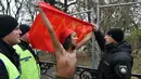 Petugas menghalau aktivis wanita gerakan hak perempuan Femen saat unjuk rasa memperingati 100 tahun Revolusi Bolshevik di pusat kota Kiev, Ukraina (7/11). (AFP Photo/Genya Savilov)