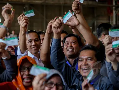 Presiden Joko Widodo (tengah) berfoto bersama para pekerja usai penyerahan Kartu Indonesia Sehat (KIS) untuk pekerja di PT Dok dan Perkapalan Kodja Bahari, Cilincing, Jakarta, Selasa (28/4/2015). (Liputan6.com/Faizal Fanani)