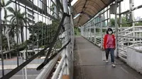Pejalan kaki melintasi jembatan penyeberangan orang (JPO) di Jalan Sudirman, Jakarta, Jumat (27/4).  Pemprov DKI Jakarta akan merevitalisasi 12 JPO di sepanjang Jalan Sudirman dan Jalan MH Thamrin. (Liputan6.com/Arya Manggala)