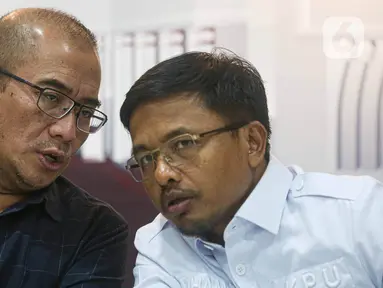 Ketua Komisi Pemilihan Umum (KPU) Republik Indonesia Hasyim Asy’ari (kiri) berbincang bersama anggota KPU RI Idham Holik disela-sela konferensi pers terkait pendaftaran pasangan calon presiden dan calon wakil presiden di Gedung KPU RI, Jakarta, Senin (16/10/2023). (Liputan6.com/Faizal Fanani)
