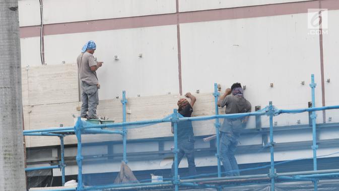 Pekerja mengerjakan pemasangan dinding di salah satu bangunan di Jakarta, Selasa (15/1). Kemenaker mencatat kecelakaan kerja terjadi di tempat kerja maupun dalam perjalanan ke atau dari tempat kerja. (Liputan6.com/Angga Yuniar)