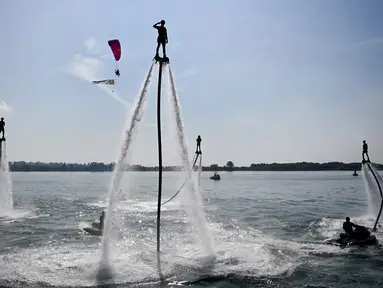 Seorang flyboarder (tengah) memberi hormat saat gladi bersih sehari jelang upacara pembukaan latihan angkatan laut multilateral Komodo 2025 di pelabuhan Benoa, Denpasar, Bali, pada 15 Februari 2025. (SONNY TUMBELAKA/AFP)