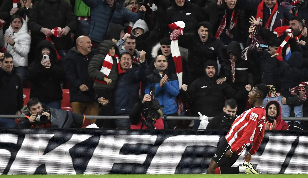 Pemain Athletic Bilbao, Nico Williams, melakukan selebrasi setelah mencetak gol ke gawang Atletico Madrid pada laga semifinal Copa del Rey di Stadion San Mames, Jumat (1/3/2024). Bilbao menang dengan skor 3-0. (AFP/Ander Gillenea)
