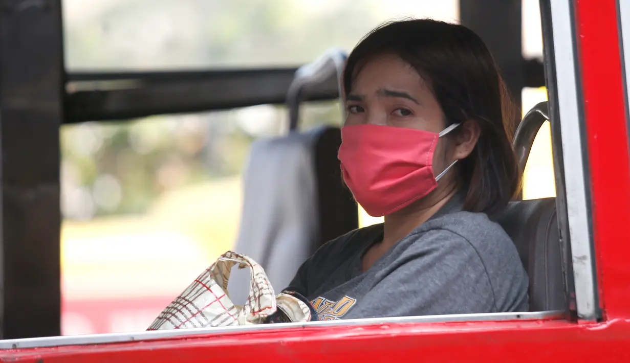 Seorang wanita mengenakan masker pelindung di sebuah bus umum di Bangkok, Thailand (14/1). Tingkat kabut asap yang sangat tinggi diperburuk oleh pola cuaca yang meningkatkan kewaspadaan di seluruh Asia. (AP Photo/Sakchai Lalit)