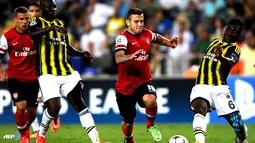 Duel perebutan bola antara Jack Wilshere dengan Joseph Yobo pada pertandingan Play-off Liga Champions antara Fenerbahce melawan Arsenal di Stadion Sukru Saracoglu di Istanbul pada 21 Agustus 2013. (AFP/Bulent Kilic)