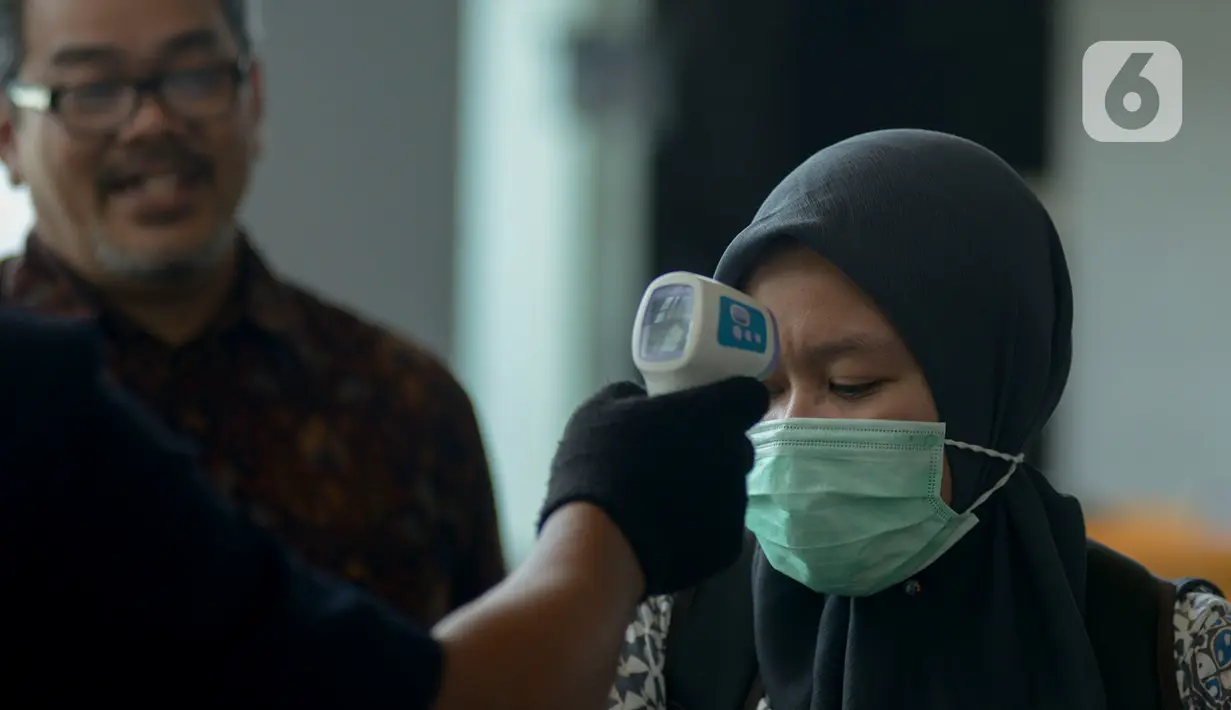 Pekerja menjalani pemeriksaan suhu tubuh di salah satu perkantoran di Jakarta, Selasa (3/3/2020). Pemeriksaan suhu tubuh tersebut untuk mengantisipasi penyebaran virus corona atau COVID-19 di lingkungan kerja. (merdeka.com/Imam Buhori)