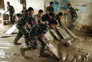Meski fasilitas fisik mulai membaik, banyak peralatan medis yang ada di Rumah Sakit Daerah Aceh Tamiang dilaporkan rusak. Tampak dalam foto, personel Tentara Nasional Indonesia (TNI) dari YONIF TP 853/BRB, Aceh Timur, membersihkan lumpur di Rumah Sakit Daerah di Aceh Tamiang, pada 16 Desember 2025, setelah banjir bandang sekitar tiga minggu lalu. (Yasuyoshi Chiba/AFP)
