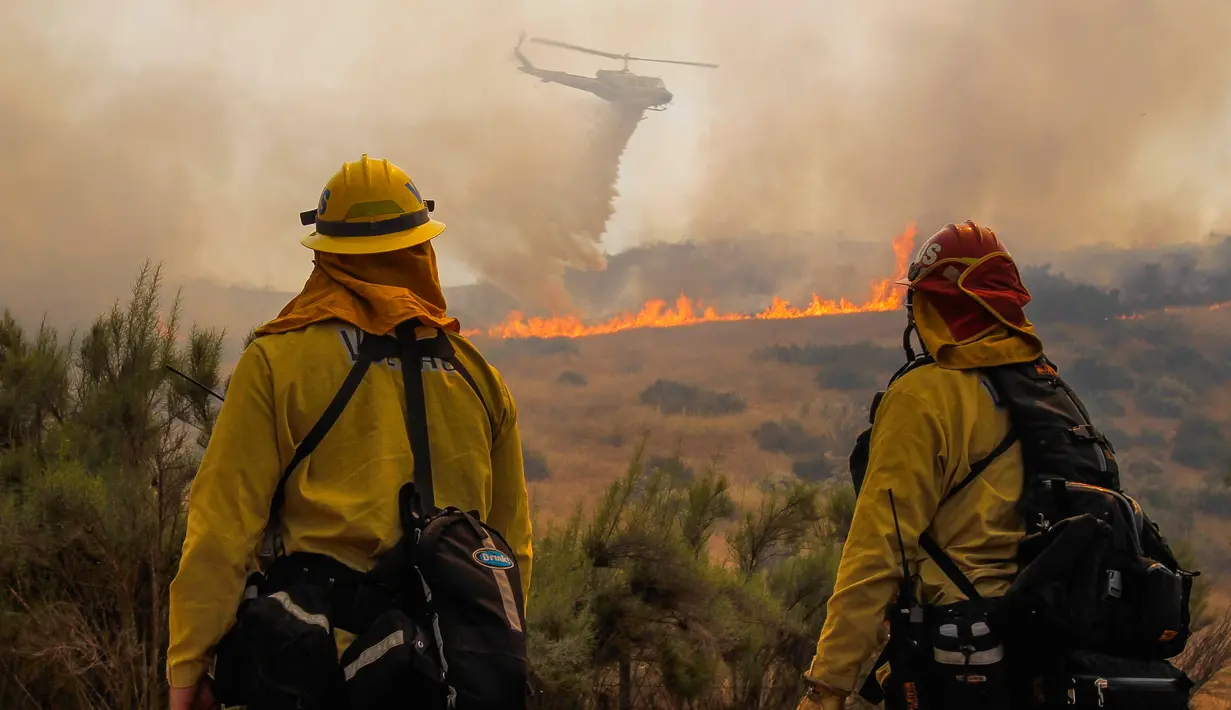 Sebuah helikopter menjatuhkan air pada area yang terbakar di California, Amerika Serikat, Sabtu (20/5). Kebakaran tersebut melahap lahan seluas 1000 hektar. (AP Photo/Hayne Palmour IV)