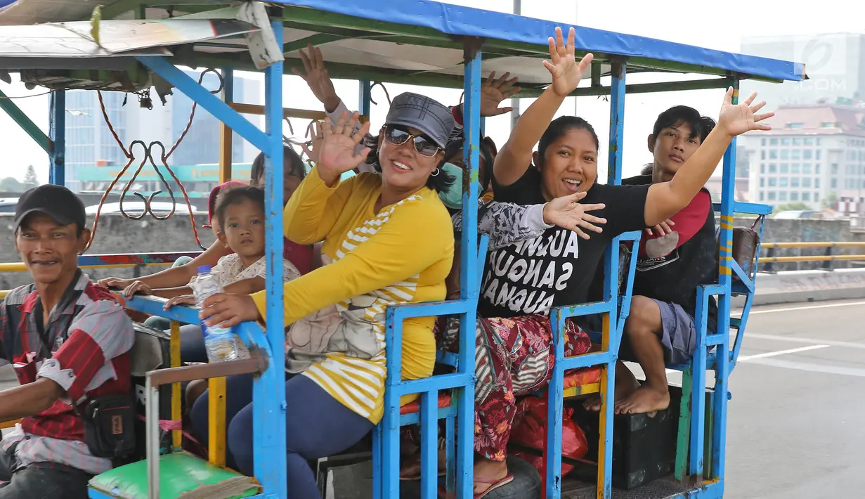 Sejumlah warga menaiki bak terbuka motor roda tiga menuju Kebun Binatang Ragunan di kawasan Jakarta, Minggu (9/6/2019). Warga memanfaatkan motor roda tiga untuk bepergian bersama keluarga menuju sejumlah objek wisata karena dianggap lebih hemat biaya. (Liputan6.com/Herman Zakharia)
