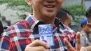 Cagub DKI no urut dua, Basuki T Purnama menunujukkan id anggota Slankers usai melakukan pertemuan tertutup dengan personil grup band Slank di markas Slank, Jakarta, Kamis (22/12/2016). (Liputan6.com/Herman Zakharia)