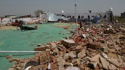 Sebuah tembok bangunan ambruk di pesta pernikahan di Bharatpur, India, Kamis (11/5). insiden nahas tersebut terjadi ketika badai pasir menyebabkan tembok roboh dan menimpa para tamu yang tengah menikmati hidangan di pesta pernikahan. (MONEY SHARMA/AFP)