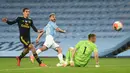 Pemain Manchester City Sergio Aguero (tengah) mencungkil bola melewati kiper Arsenal Jerman Bernd Leno (tengah) pada laga Premier League di Etihad Stadium, Manchester, Inggris, Rabu (17/6/2020). Manchester City menang dengan skor 3-0. (PETER POWELL/POOL/AFP)