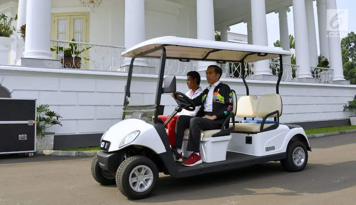 Presiden Joko Widodo atau Jokowi dan sprinter Lalu Muhammad Zohri menaiki mobil golf di Istana Bogor, Jawa Barat, Rabu (18/7). Jokowi tampak mengenakan jaket Asian Games saat menerima kedatangan Zohri. (Liputan6.com/Pool/Biro Pers Setpres)