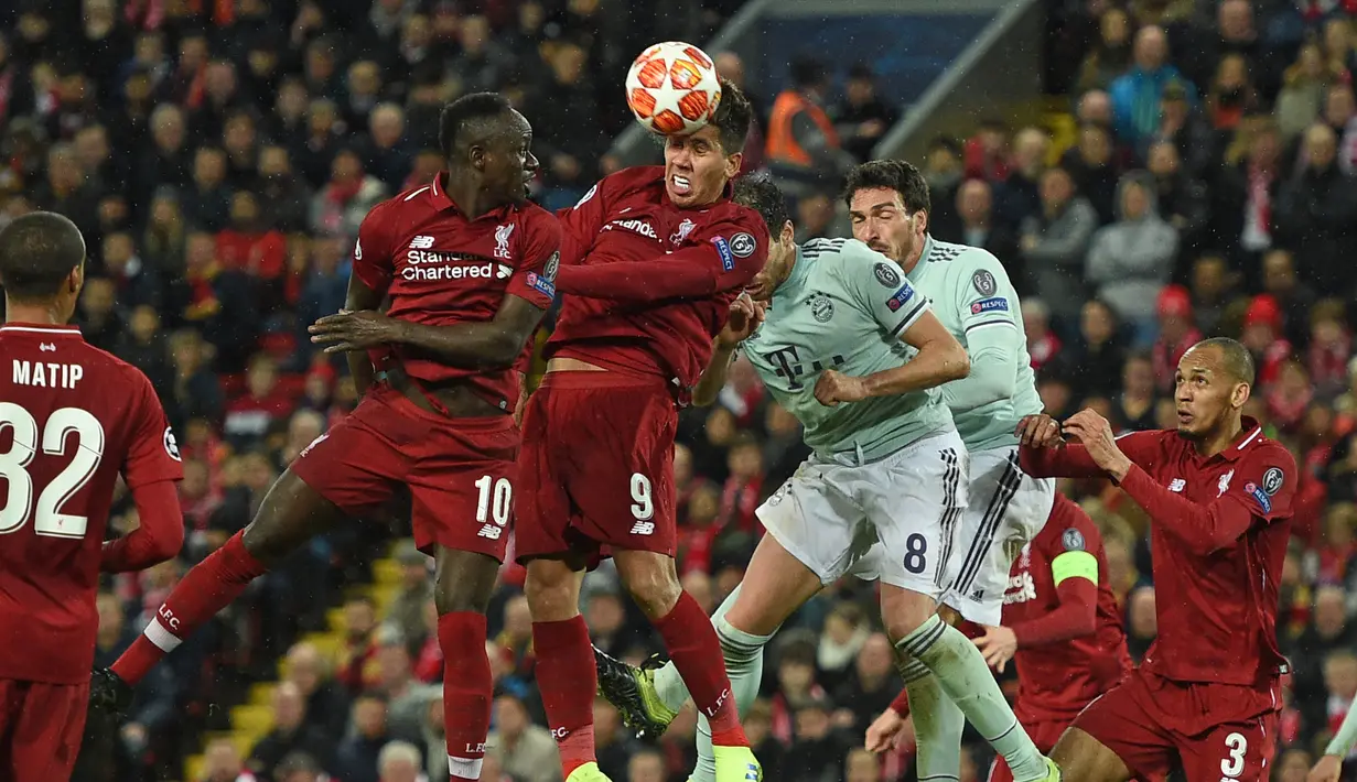 Duel udara yang dilakukan oleh penyerang Liverpool. Roberto Firminho pada leg 1, babak 16 besar Liga Champions yang berlangsung di stadion Anfield, Liverpool, Rabu (20/2). Liverpool imbang 0-0 kontra Bayern Munchen. (AFP/Oli Scarff)