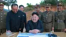 Pemimpin Korea Utara Kim Jong Un saat berada di tempat peluncuran Rudal ballistik jarak jauh Hwasong-12 (Mars-12) di Korea Utara, Selasa (15/5). Rudal Hwansong-12 mampu mencapai ketinggian 2.000km dan menempuh jarak sekitar 700km. (AFP/KCNA)