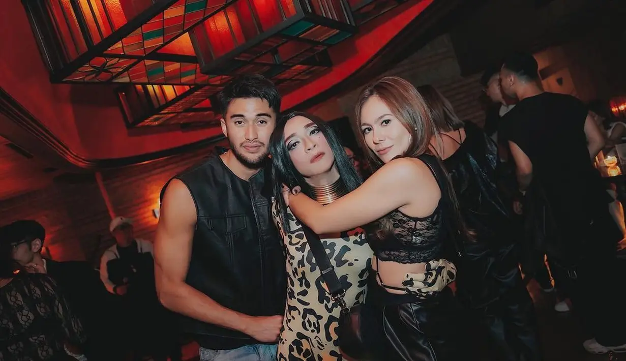 Begitu juga dengan outfit Wulan Guritno dan pasangannya Sabda Ahessa. Wulan memakai sleeveless crop top renda dan leather pants warna hitam (Foto: Instagram @amingisback)