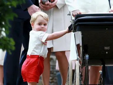 Pangeran George tampak memegangi kereta bayi sang adik, Putri Charlotte usai upacara pembaptisan Charlotte selesai di Gereja St. Mary Magdalene, Sandringham, Inggris, Minggu (5/7/2015). (REUTERS/Chris Jackson/Pool)